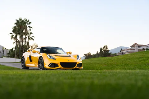 Front three-quarter view of the Exige on a lawn at golden hour