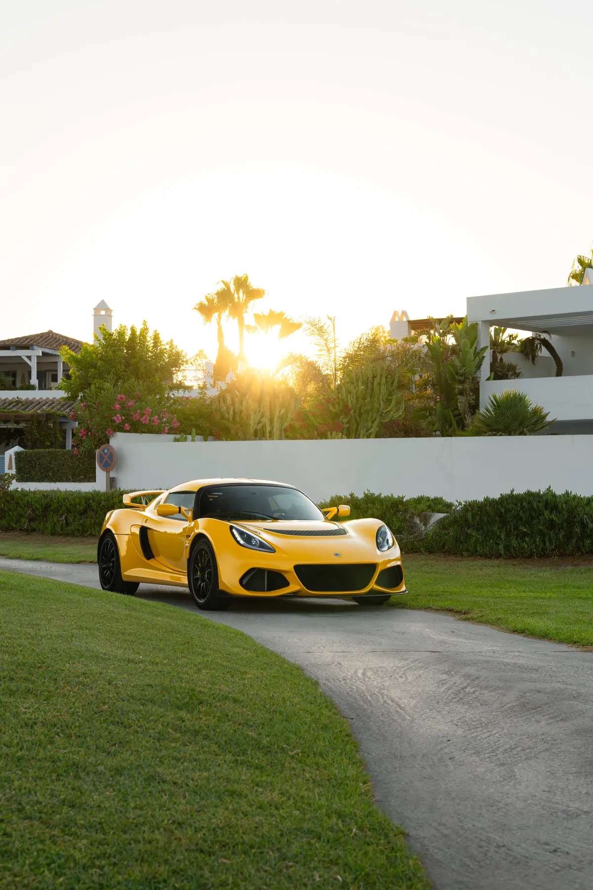 The Exige backlit by a low sun, yellow paint glowing