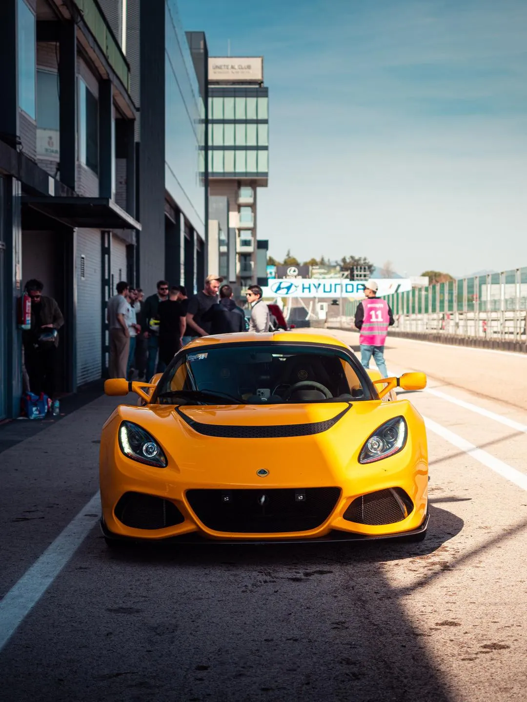 The Exige in the pit lane with a crowd gathered around it