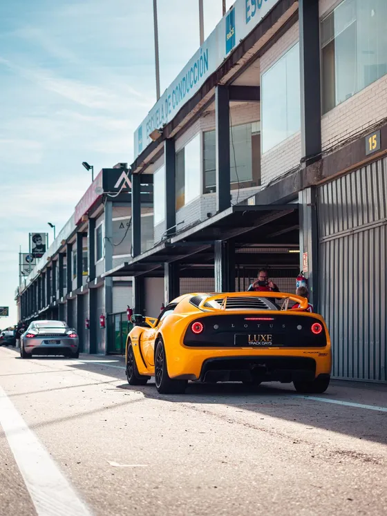 The Exige from behind in the pit lane, garages either side